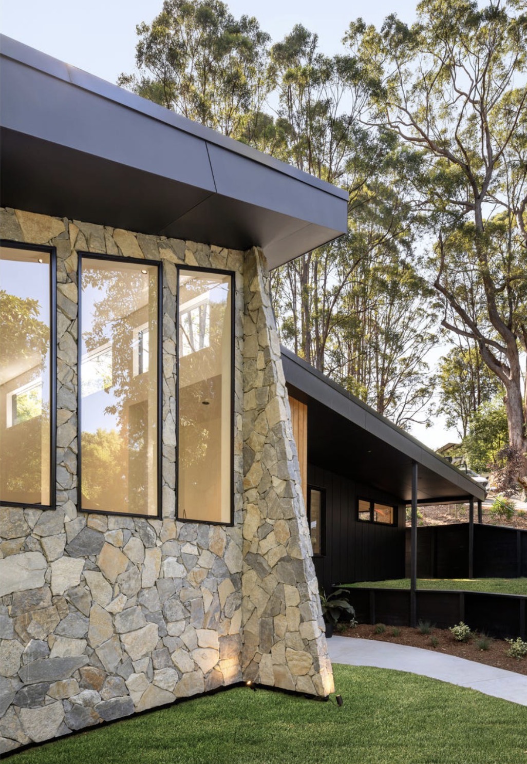 Stone, timber and dark rooflines at Tallowood Residence, designed and built by Ecostruct.